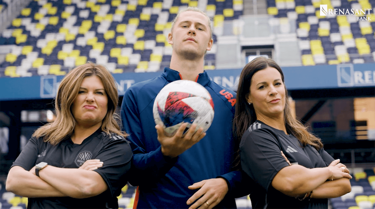 Walker Zimmerman holds  soccer ball in between Courtney and Sarah