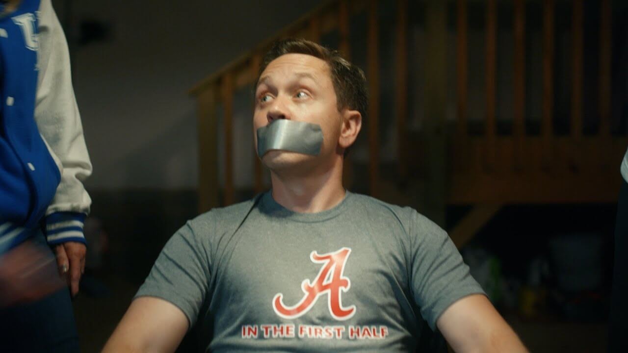 Man in Alabama shirt with duct tape around his mouth