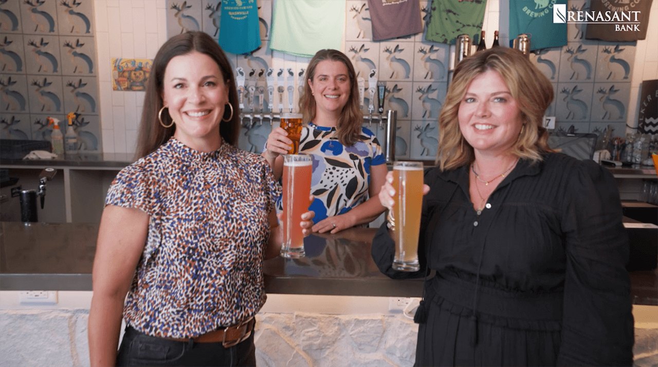 Three women standing in a brewery