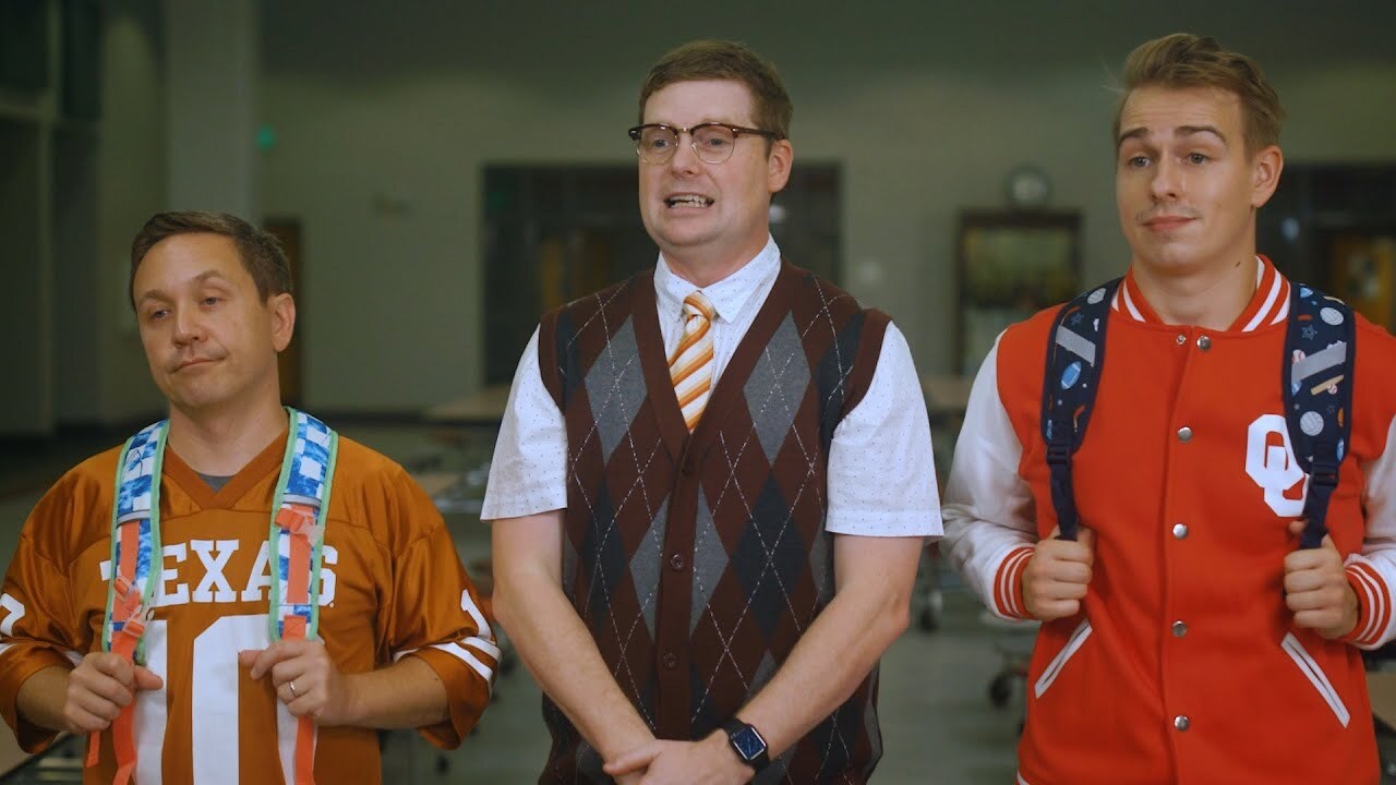 Guy in texas jersey, guy in sweatervst, and guy in Oklahoma letterman jacket