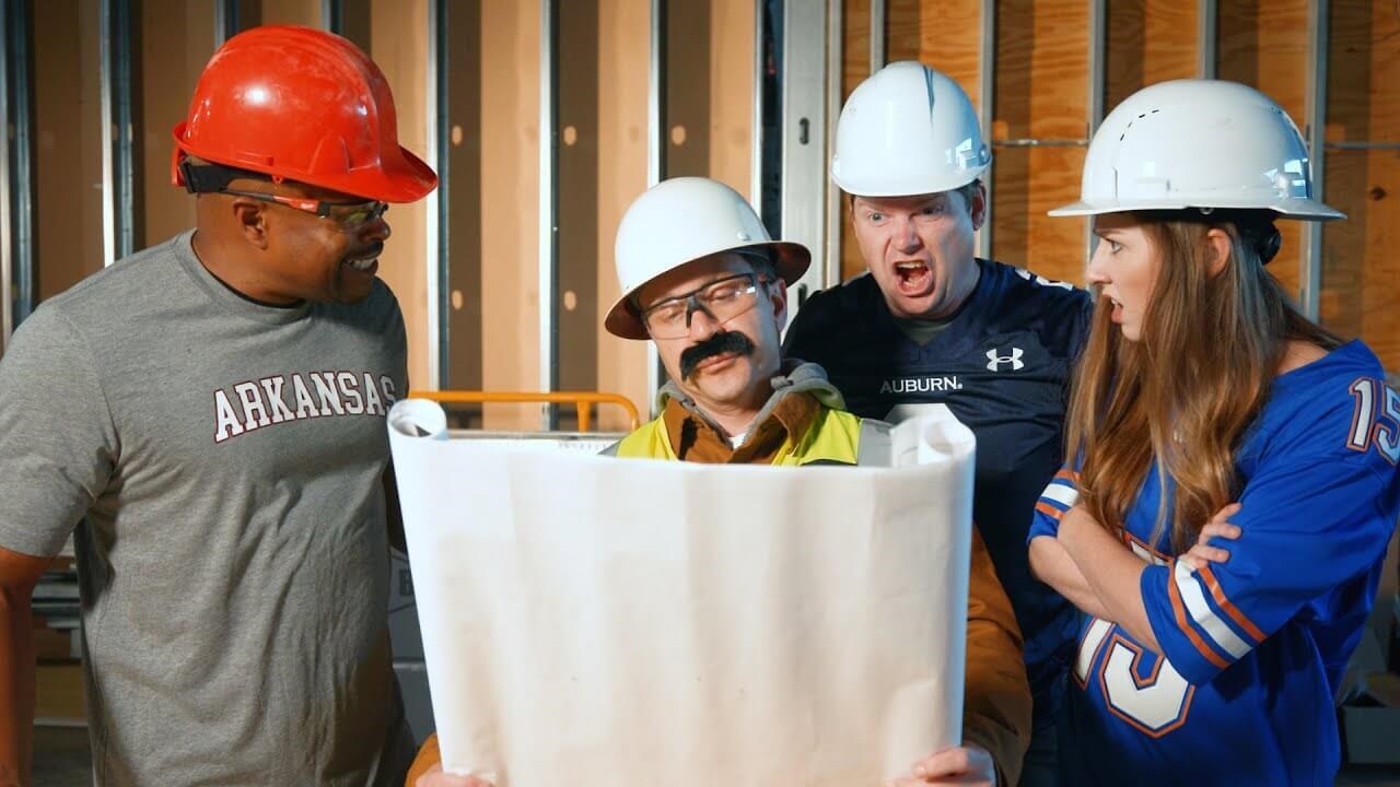 three men and a woman in hard hats looking at a construction plan