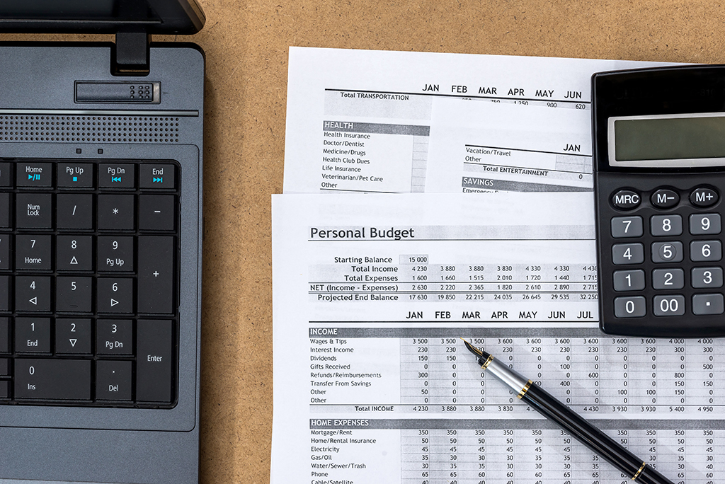 Personal Budget papers with a calculator, laptop and pencil