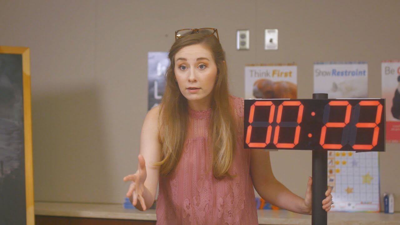 Tutor holding a timer. 