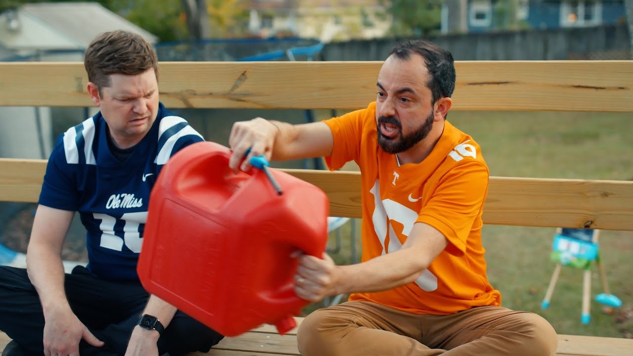 guy in ole miss jersey and guy in tennessee jersey with a can of gasoline
